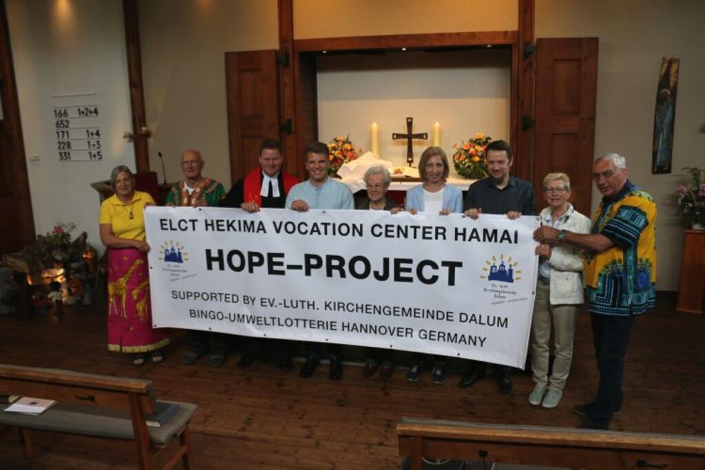 Die Delegation rund um den Partnerschaftsausschuss mit Walter und Jacoba Schulz, Pastor i. R. Diedrich Kohnert und Pastor Thorsten Jacobs und Sohn Mathis mit dem Banner, das zukünftig im Eingangsbereich der neuen Berufsschule in Hamai hängen wird